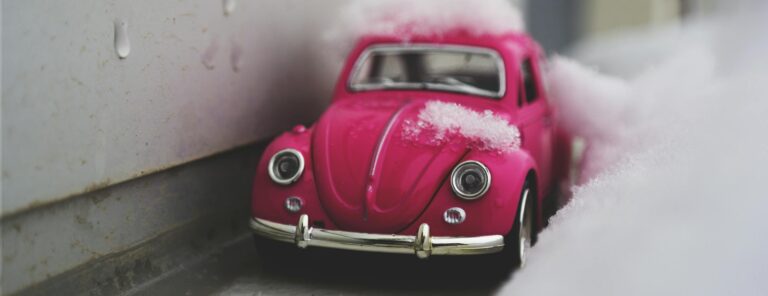 Red Volkswagen Beetle Die-cast Metal Model Beside White Wall