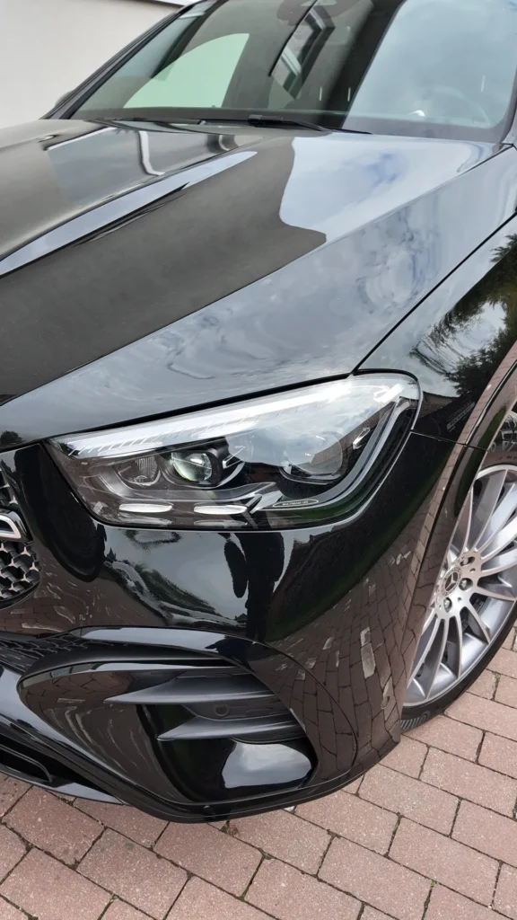 Widok z przodu reflektora i zderzaka czarnego SUV-a marki Mercedes-Benz, pokrytego matową folią ochronną PPF.