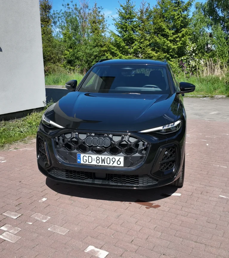 Czarny SUV marki Audi zaparkowany na nawierzchni wyłożonej cegłą, z polską tablicą rejestracyjną o numerze GD 8W096.