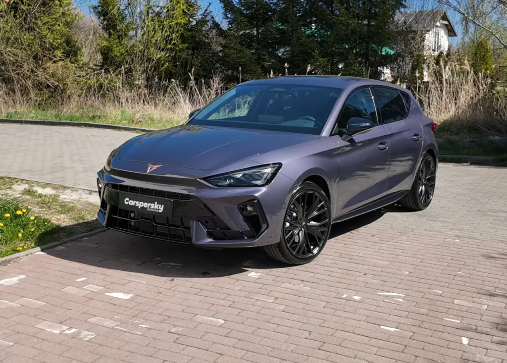 Szary elektryczny hatchback Cupra Born z pełną przednią folią ochronną (PPF), zaparkowany na utwardzonym parkingu.
